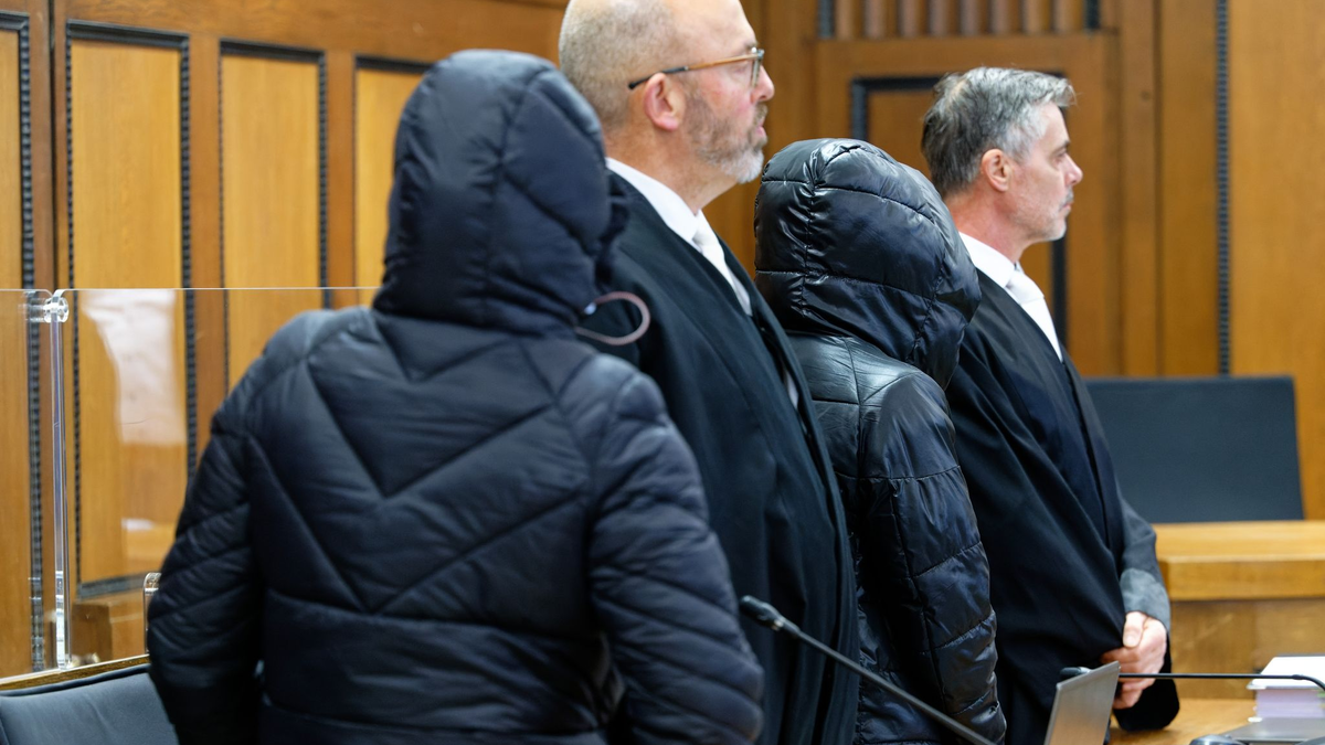 Die beiden Angeklagten und die Rechtsanwälte vor Beginn der Verhandlung im Gerichtssaal. - Foto: Henning Kaiser/dpa