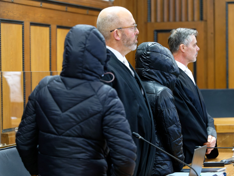 Die beiden Angeklagten und die Rechtsanwälte vor Beginn der Verhandlung im Gerichtssaal. - Foto: Henning Kaiser/dpa