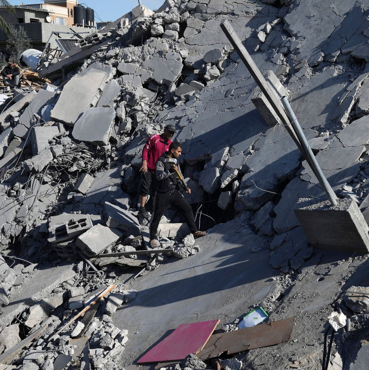 Palästinenser suchen nach einem israelischen Luftangriff im Flüchtlingslager Nusseirat nach Überlebenden. - Foto: Adel Hana/AP/dpa