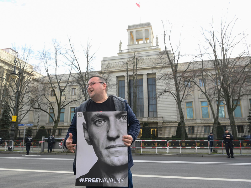 Ein Aktivist steht mit einem Plakat von Kremlkritiker Alexej Nawalny vor der russichen Botschaft in Berlin und protestiert. - Foto: Paul Zinken/dpa