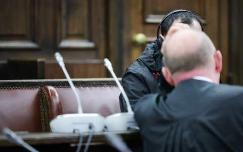 Einer der beiden Angeklagten (verdeckt) spricht mit seinem Anwalt Hannes Linke vor Prozessbeginn im Gerichtssaal des Strafjustizgebäudes. - Foto: Christian Charisius/dpa-Pool/dpa