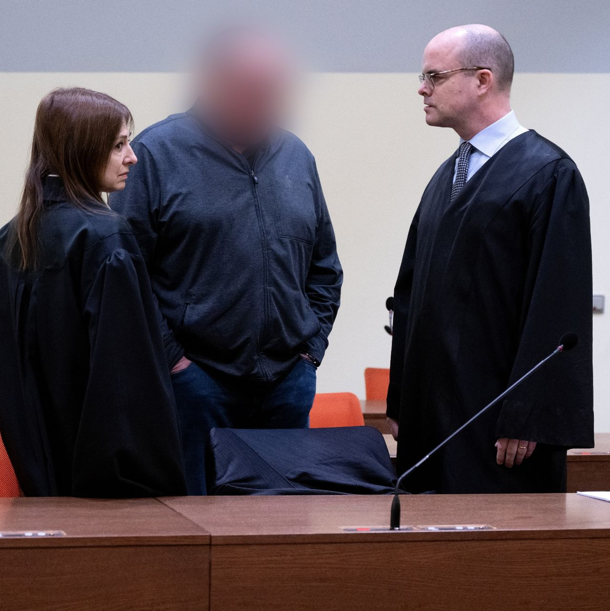 Der angeklagte Lokführer (M) steht mit seiner Anwältin und seinem Anwalt im Gerichtssaal in München. - Foto: Sven Hoppe/dpa