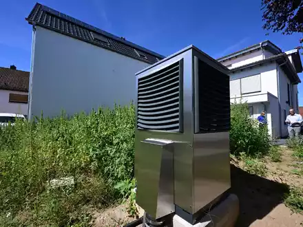 Eine Wärmepumpe steht in einem Garten. Die Ampel strebt an, dass 2024 500.000 Geräte installiert werden. Das sei «illusorisch», sagt Michael Hilpert, Verbandspräsident der Zentralverband Sanitär Heizung Klima. - Foto: Bernd Weißbrod/dpa