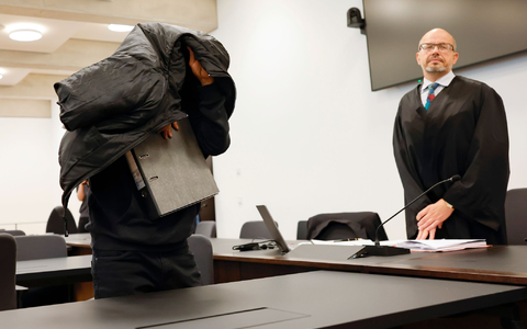 Der ehemalige Security-Mann bedeckt im Gerichtsaal seinen Kopf mit einer Jacke. - Foto: Daniel Löb/dpa