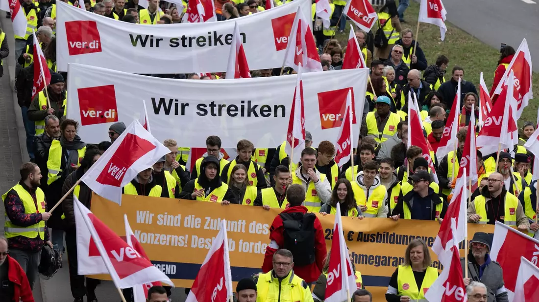In einem Protestzug ziehen Warnstreik-Teilnehmer in Richtung Terminal 1 in Frankfurt. - Bild: Boris Roessler/dpa
