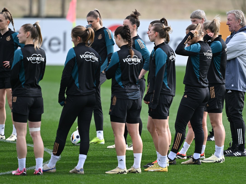 Horst Hrubesch (r) und die DFB-Spielerinnen beim Training auf dem DFB-Campus. - Foto: Arne Dedert/dpa