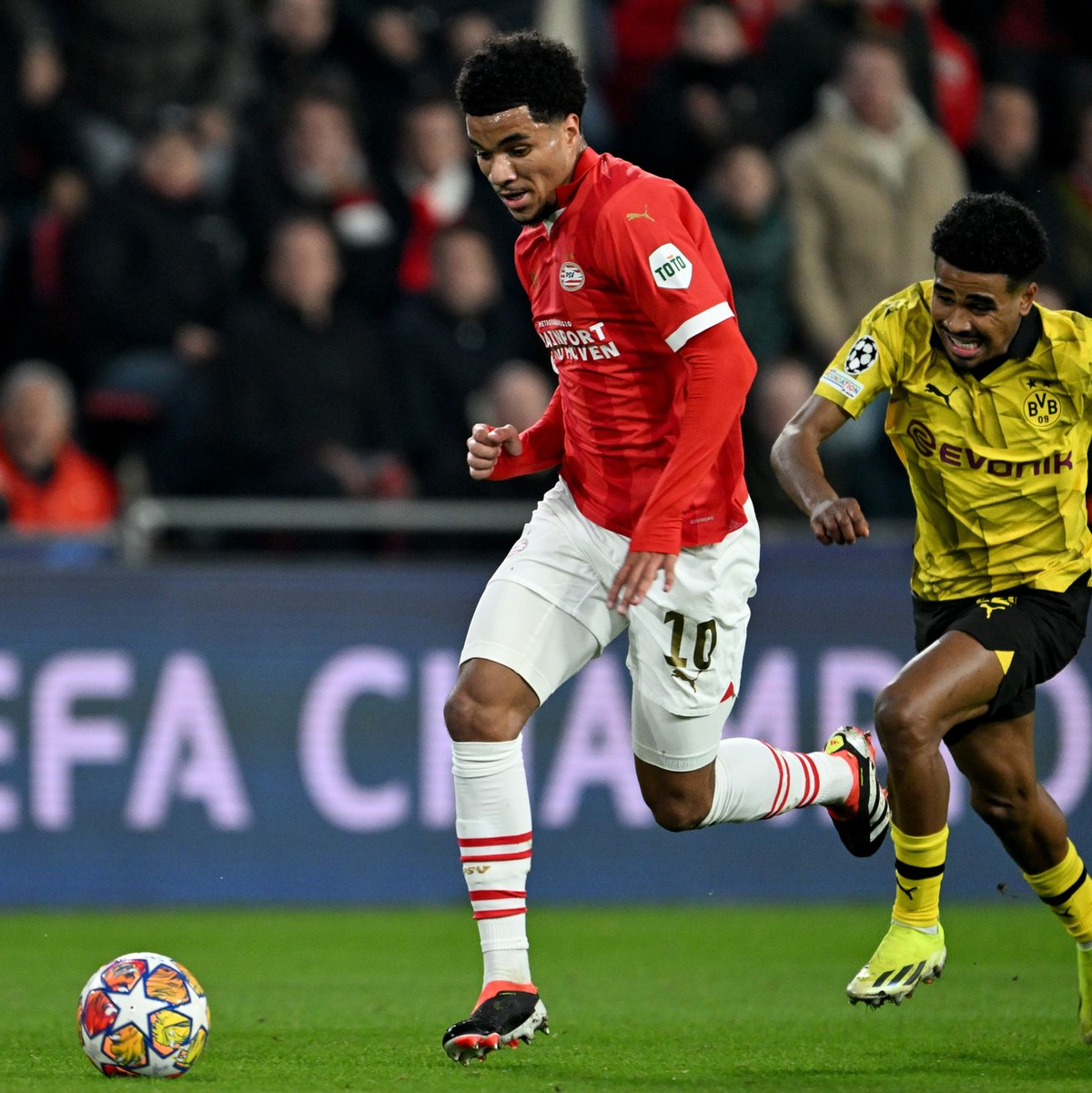 Eindhovens Malik Tillman (l) im Laufduell mit Dortmunds Ian Maatsen. - Foto: Federico Gambarini/dpa