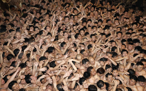 Männer, die nur mit einem Lendenschurz bekleidet sind, drängeln sich bei dem über 500 Jahre alten Saidaiji-Eyo-Festival im Saidaiji-Tempel, um einen heiligen Holzstab zu ergattern. - Foto: -/kyodo/dpa