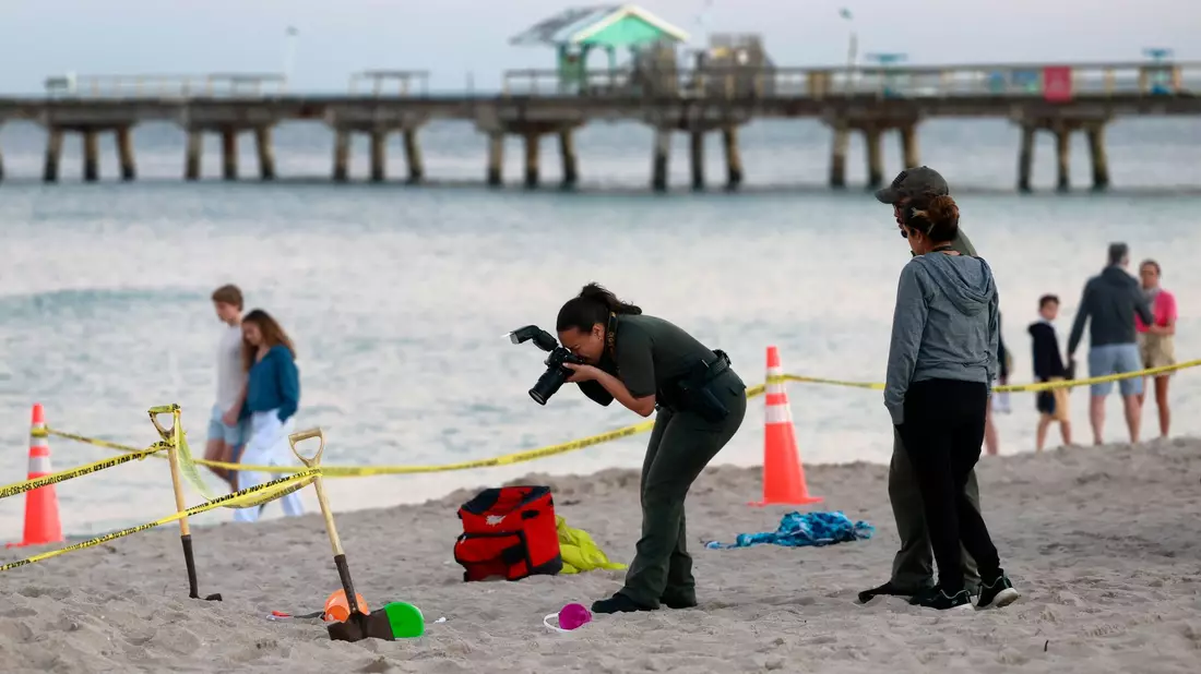 Eine Polizistin macht am Strand von Lauderdale-by-the-Sea Fotos vom Tatort. - Bild: Mike Stocker/South Florida Sun-Sentinel/AP/dpa