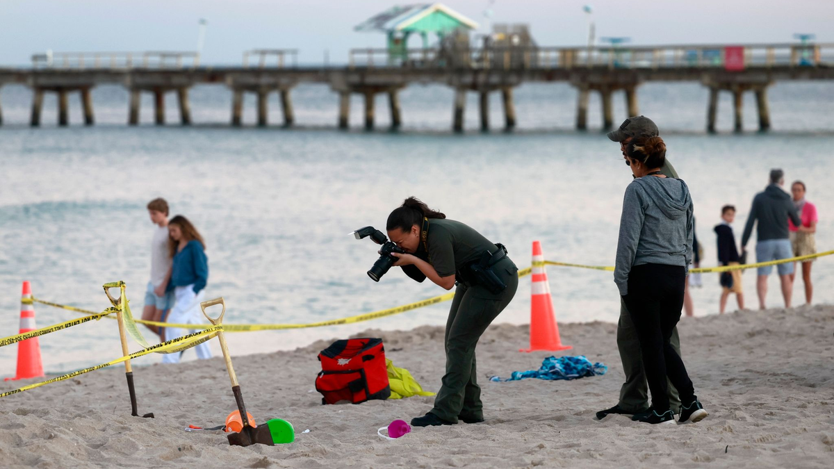 Eine Polizistin macht am Strand von Lauderdale-by-the-Sea Fotos vom Tatort. - Foto: Mike Stocker/South Florida Sun-Sentinel/AP/dpa