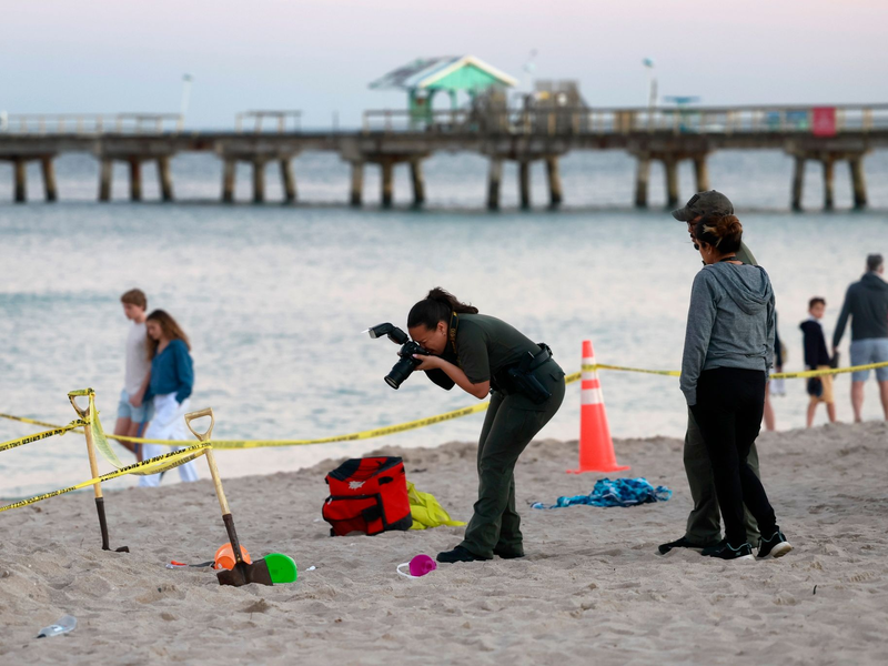 Eine Polizistin macht am Strand von Lauderdale-by-the-Sea Fotos vom Tatort. - Foto: Mike Stocker/South Florida Sun-Sentinel/AP/dpa