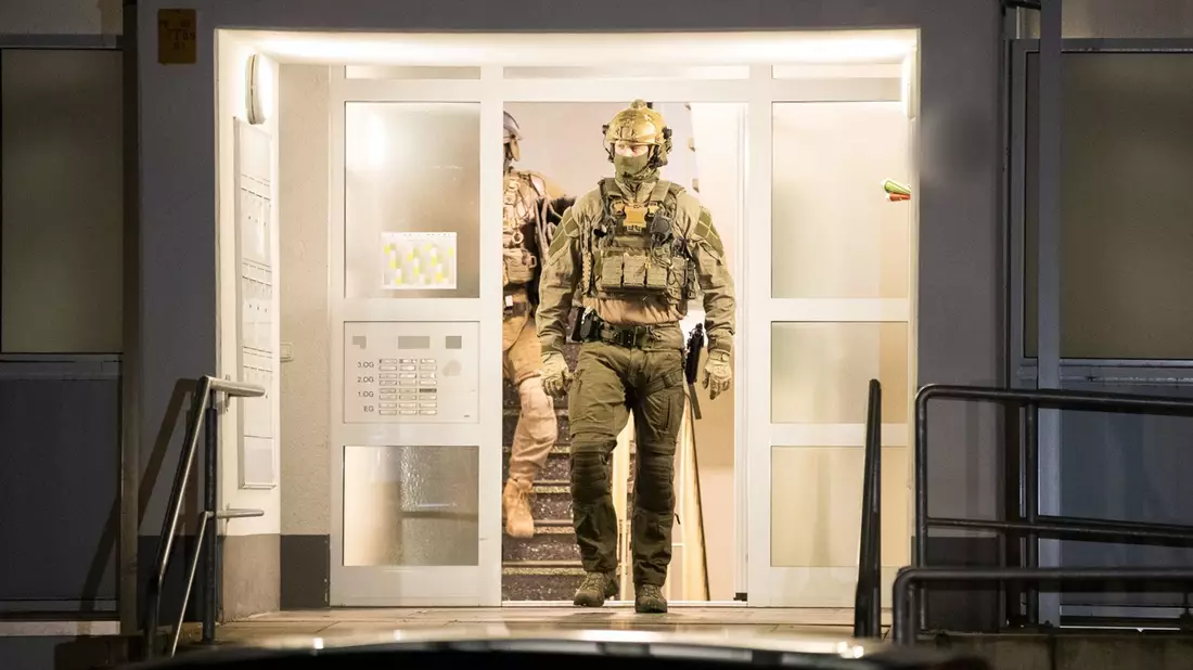 Einsatzkräfte der Polizei verlassen ein Gebäude in Düsseldorf. - Bild: Justin Brosch/dpa