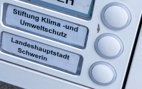 Das Klingelschild der Stiftung Klima- und Umweltschutz am Eingang eines Wohn- und Geschäftshauses. Die geplante Auflösung der Klimastiftung MV ist heftig umstritten. - Foto: Jens Büttner/dpa