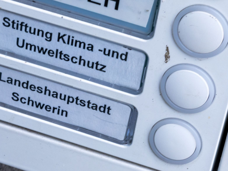Das Klingelschild der Stiftung Klima- und Umweltschutz am Eingang eines Wohn- und Geschäftshauses. Die geplante Auflösung der Klimastiftung MV ist heftig umstritten. - Foto: Jens Büttner/dpa