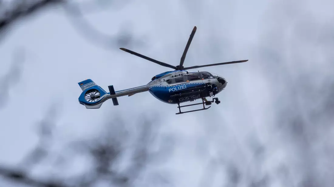 Der Polizei-Hubschrauber kreist über der Schule in Wuppertal. - Bild: Christoph Reichwein/dpa