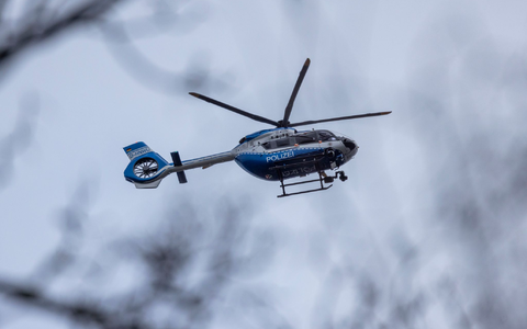Der Polizei-Hubschrauber kreist über der Schule in Wuppertal. - Foto: Christoph Reichwein/dpa