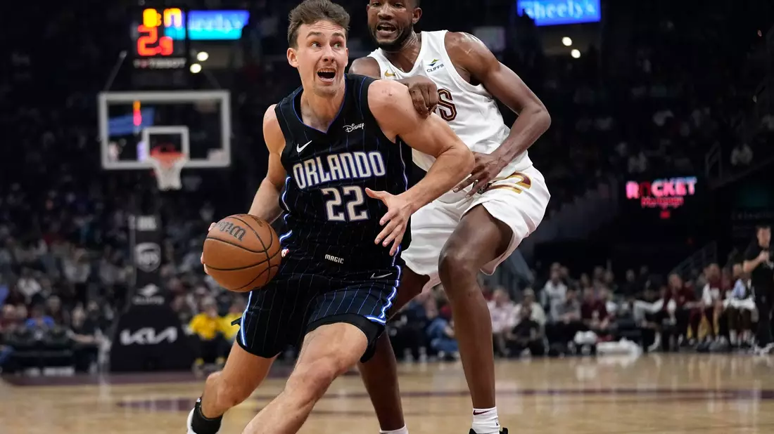 Orlandos Franz Wagner (22) zieht an Evan Mobley von den Cleveland Cavaliers vorbei. - Bild: Sue Ogrocki/AP/dpa