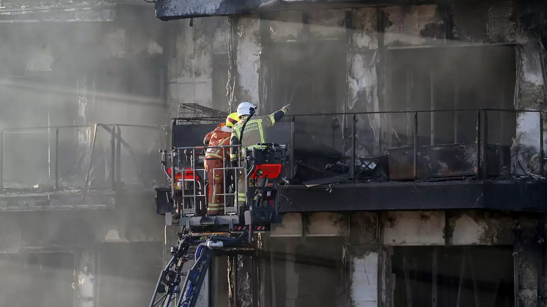 Feuerwehrleute bei den Löscharbeiten auf einer Hubleiter. - Bild: Alberto Saiz/AP/dpa