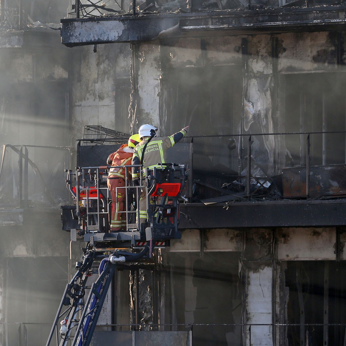 Feuerwehrleute bei den Löscharbeiten auf einer Hubleiter. - Foto: Alberto Saiz/AP/dpa