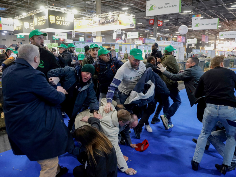 Landwirte raufen mit dem Sicherheitspersonal auf der Internationalen Landwirtschaftsmesse, während der französische Präsident Macron die Ausstellung am Eröffnungstag besucht. - Foto: Ludovic Marin/AFP Pool/AP/dpa