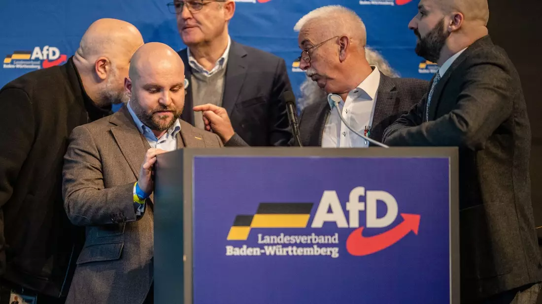 AfD-Politiker um Markus Frohnmaier  beratschlagen in der Stadthalle über das weitere Vorgehen beim Landesparteitag. - Bild: Christoph Schmidt/dpa