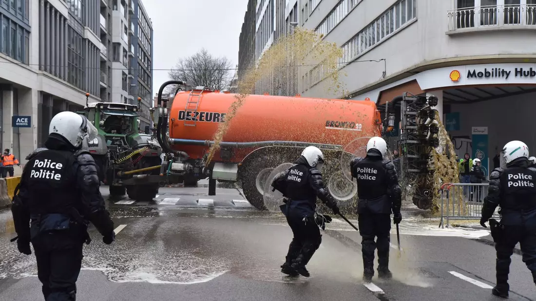 Landwirte sprühen Gülle auf die Straßen im Brüsseler Europaviertel. - Bild: Harry Nakos/AP/dpa