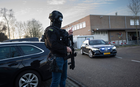 Maskierte und bewaffnete niederländische Polizisten bewachen einen Transport mit einigen der Verdächtigen, die vor dem Hochsicherheitsgebäude des Gerichts in Amsterdam eintreffen. - Foto: Peter Dejong/AP/dpa