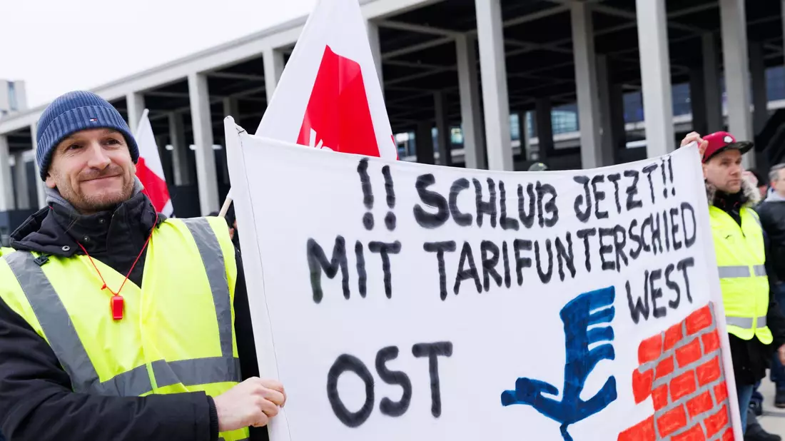 Eine Mitarbeiterin bei einer Kundgebung der Unternehmenssparte Lufthansa Technik in Berlin. - Bild: Carsten Koall/dpa