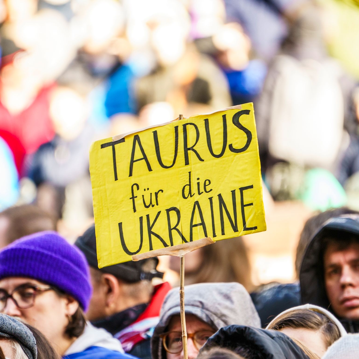 Bei einer Demonstration zum zweiten Jahrestag des russischen Angriffskrieges auf die Ukraine fordern Teilnehmer die Lieferung von Taurus-Marschflugkörper. - Foto: Andreas Arnold/dpa