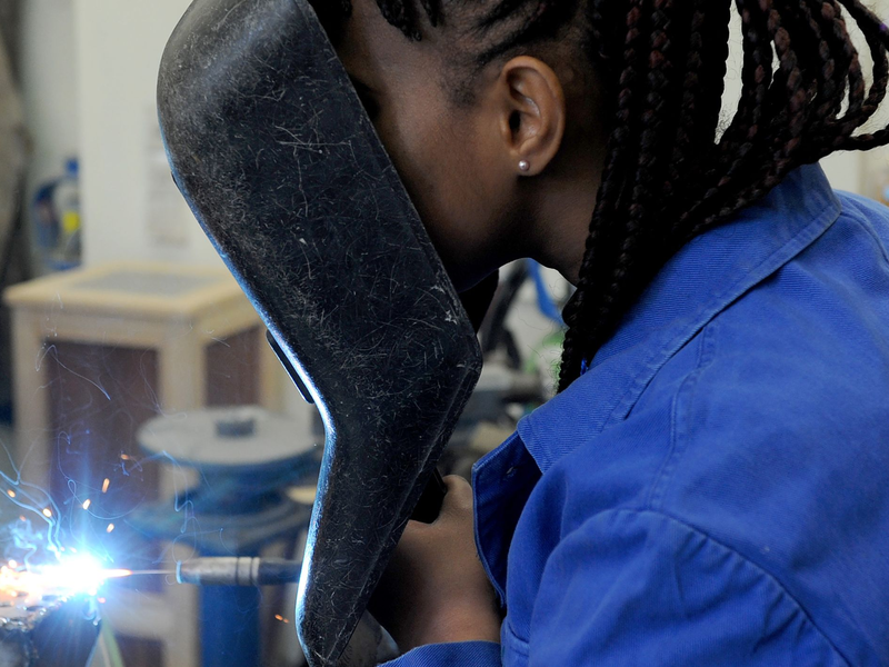 Eine Schülerin aus dem afrikanischen Guinea absolviert in der Metallwerkstatt der Allgemeinen Berufsschule in Bremen einen Kurs im E-Schweißen. - Foto: Ingo Wagner/dpa