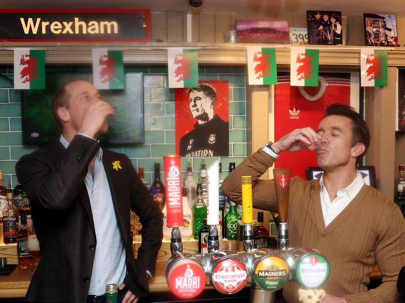 Prinz William (2.v.l) mit Rob McElhenney (2.v.r), Co-Eigentümer des Viertligisten AFC Wrexham, und den Spielern Ben Tozer (l) und Luke Young auf dem Spielfeld des Racecourse Ground, der Heimstätte von Wrexham AFC. - Foto: Chris Jackson/Pool Getty/AP/dpa