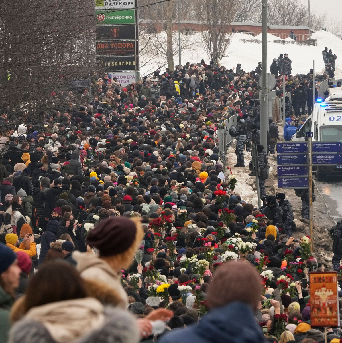 Polizisten beobachten, wie Menschen zur Beerdigungszeremonie des russischen Oppositionellen Nawalny gehen. - Foto: Uncredited/AP/dpa