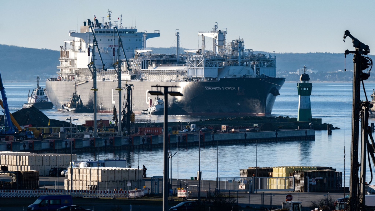 Die fast 300 Meter lange «Energos Power» läuft begleitet von Schleppern in den Hafen von Mukran ein. - Foto: Stefan Sauer/dpa