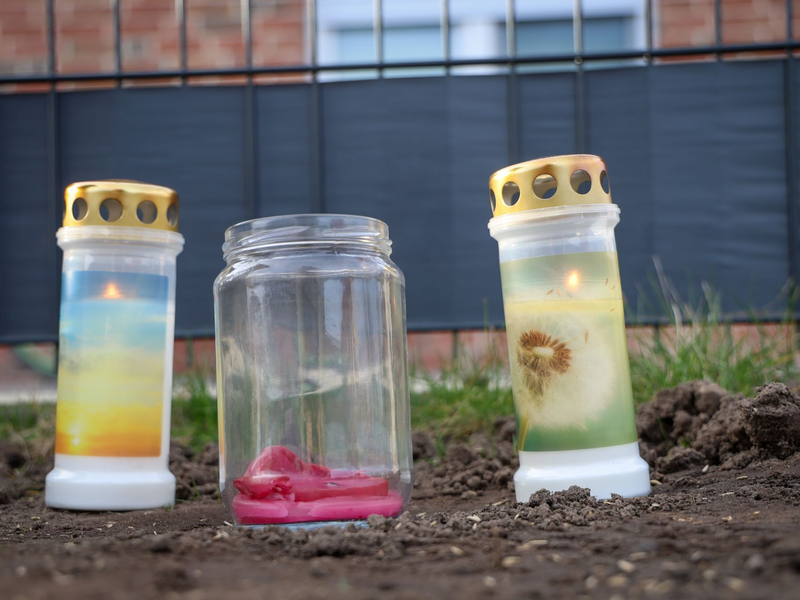 Kerzen vor einem Haus in Brockel, in dem  ein Mann zwei Menschen erschossen haben soll. - Foto: Focke Strangmann/dpa