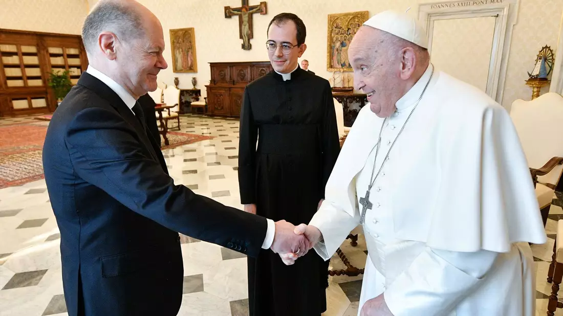 Hände schütteln zur Begrüßung: Papst Franziskus (r.)  empfängt Bundeskanzler Olaf Scholz. - Bild: Vatican Media/dpa
