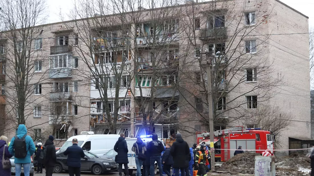 Menschen beobachten, wie Rettungskräfte nach einer Explosion an der Seite des beschädigten Wohnhauses in Sankt Petersburg arbeiten. - Bild: Uncredited/AP