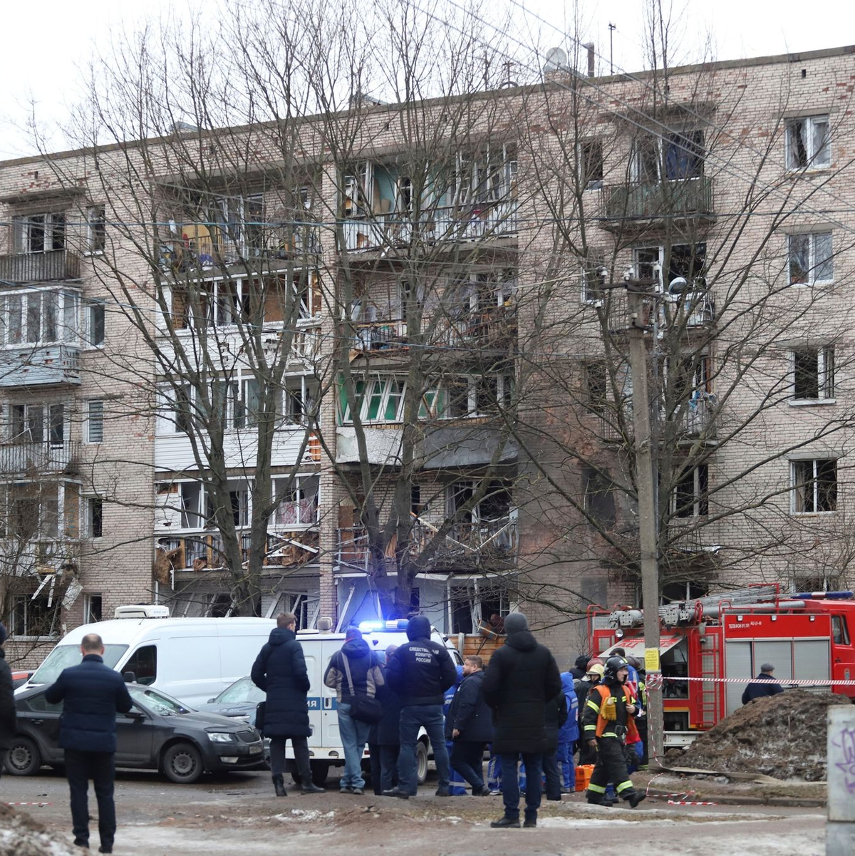 Menschen beobachten, wie Rettungskräfte nach einer Explosion an der Seite des beschädigten Wohnhauses in Sankt Petersburg arbeiten. - Foto: Uncredited/AP