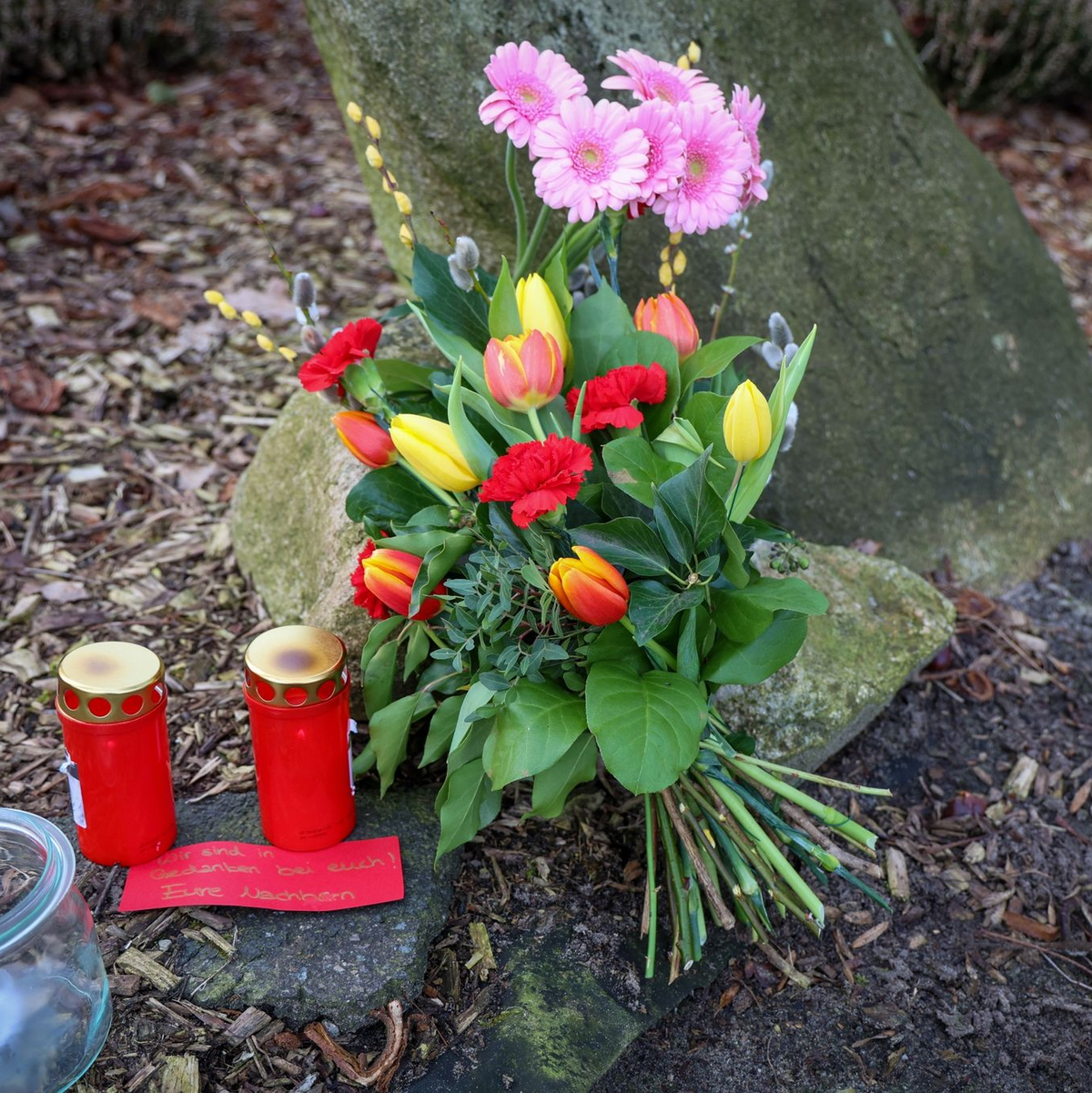 Blumen und Kerzen vor einem Haus in Westervesede in der Gemeinde Scheeßel, in dem am Vortag ein Mann zwei Personen erschossen haben soll. - Foto: Focke Strangmann/dpa