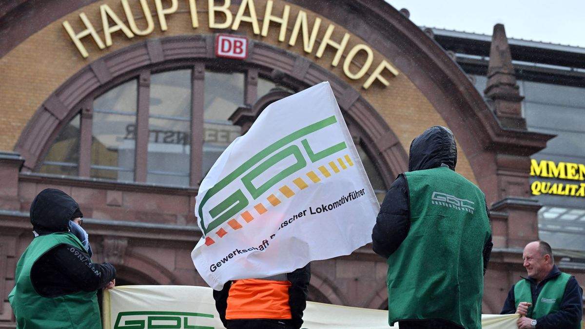 Gewerkschaftsmitglieder stehen vor dem Erfurter Hauptbahnhof. - Foto: Martin Schutt/dpa