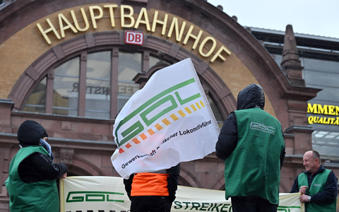 Gewerkschaftsmitglieder stehen vor dem Erfurter Hauptbahnhof. - Foto: Martin Schutt/dpa