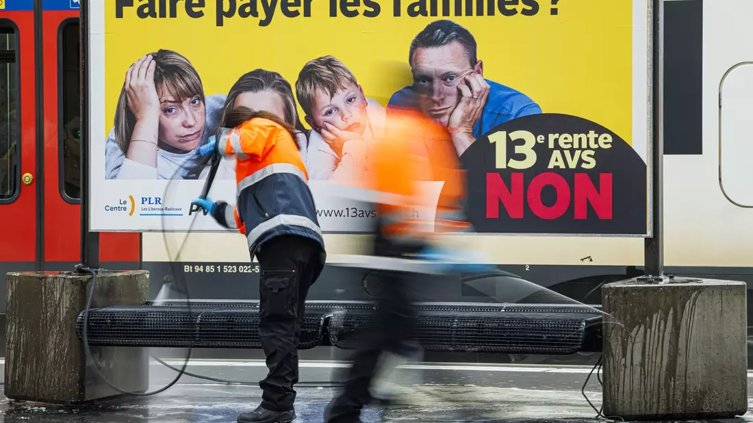 Ein Plakat des Komitees «Nein zur 13. AHV-Rente» in der französischsprachigen Schweiz am Bahnhof. - Bild: Valentin Flauraud/KEYSTONE/dpa