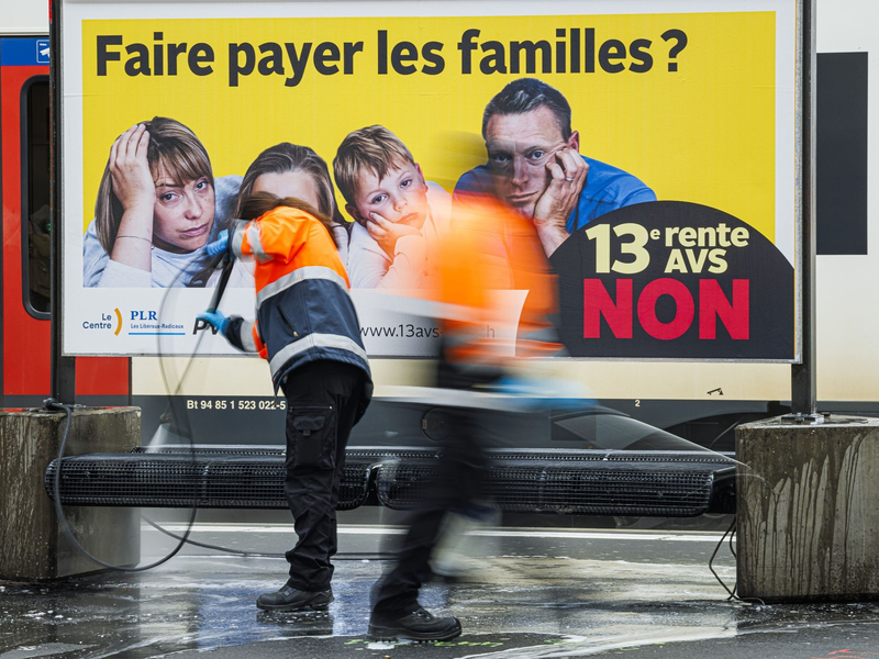 Ein Plakat des Komitees «Nein zur 13. AHV-Rente» in der französischsprachigen Schweiz am Bahnhof. - Foto: Valentin Flauraud/KEYSTONE/dpa