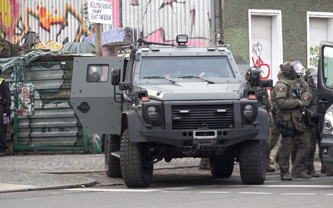 Polizisten an einem gepanzerten Fahrzeug. - Foto: Paul Zinken/dpa