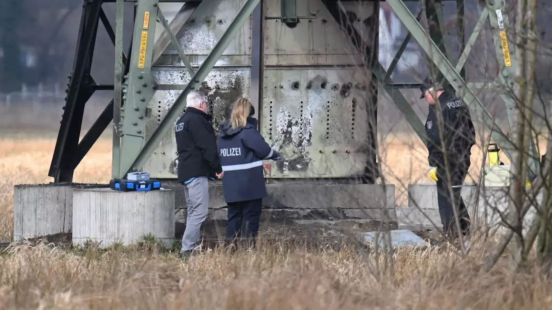 Polizei stehen an dem beschädigten Strommast in Spreenhagen. - Bild: Sebastian Gollnow/dpa