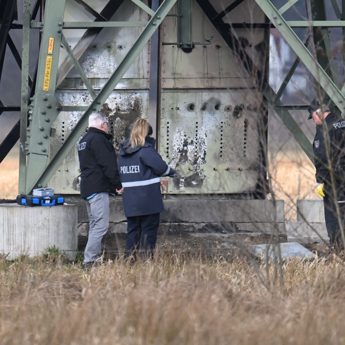 Polizei stehen an dem beschädigten Strommast in Spreenhagen. - Foto: Sebastian Gollnow/dpa