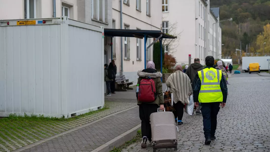 Geflüchtete kommen an einer Asylunterkunft in Trier an. Vor dem Spitzentreffen von Bund und Ländern hat der Städtetag auf die Probleme bei der Unterbringung von Geflüchteten hingewiesen. - Bild: Harald Tittel/dpa