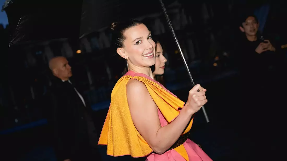 Es regnet, aber Millie Bobby Brown strahlt: Die Schauspielerin kommt zur Louis-Vuitton-Show. - Bild: Scott A Garfitt/Invision/AP/dpa