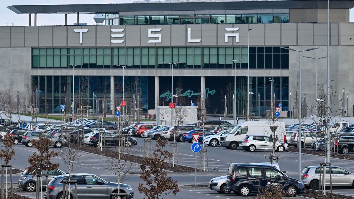 Nur wenige Autos von Mitarbeitern der Tesla-Gigafactory Berlin-Brandenburg stehen vor dem Werk. - Foto: Patrick Pleul/dpa