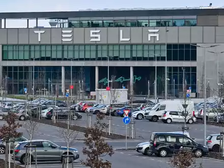 Nur wenige Autos von Mitarbeitern der Tesla-Gigafactory Berlin-Brandenburg stehen vor dem Werk. - Foto: Patrick Pleul/dpa
