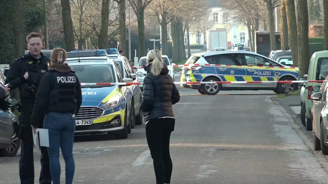 Einsatzkräfte der Polizei stehen in der Nähe des Tatorts in Ochtrup. - Bild: David Poggemann/dpa